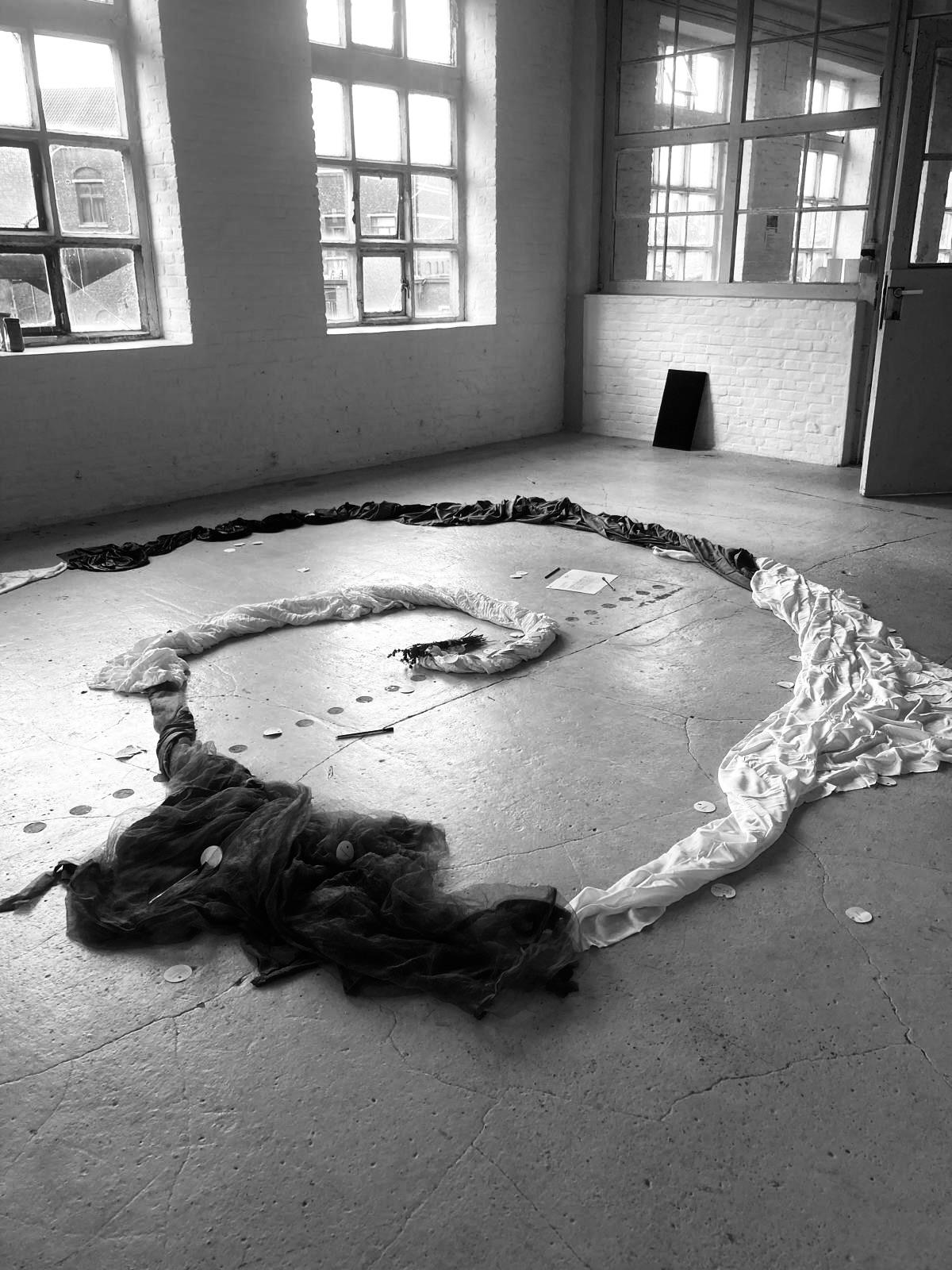 Fabrics laid out on a floor in a spiral, forming the swampmap