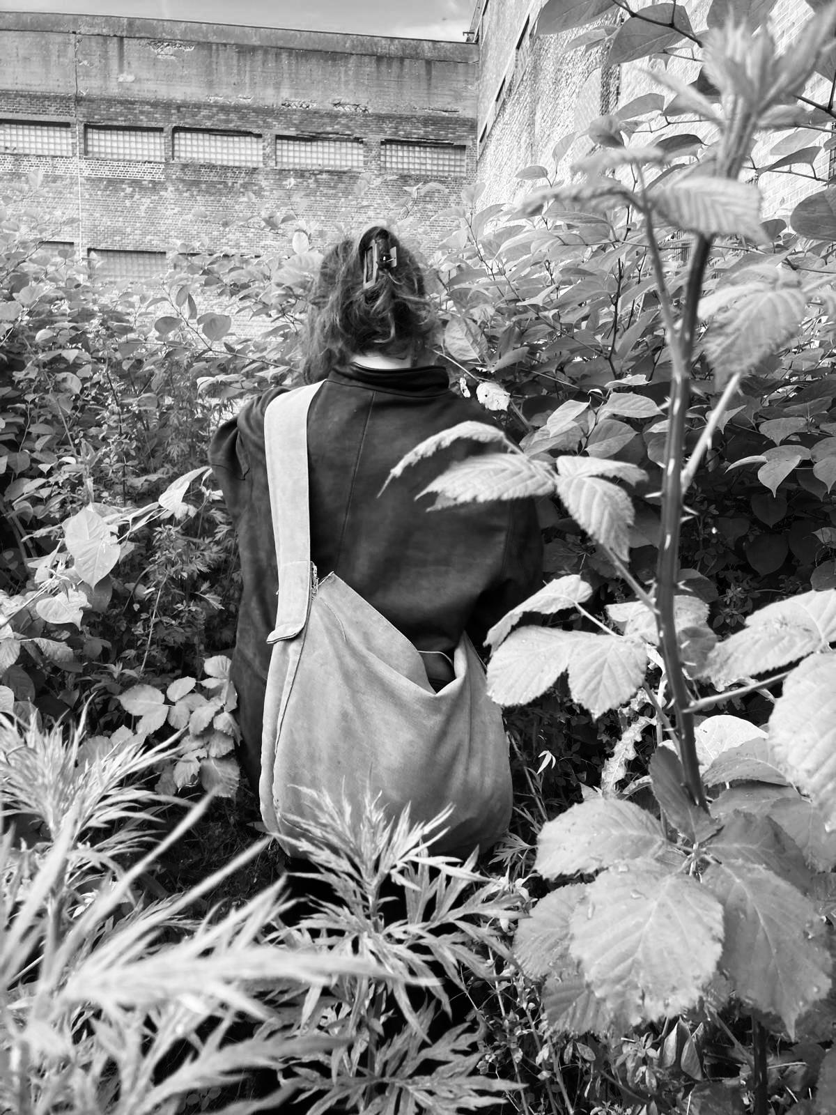 A person standing among tall summer vegetation